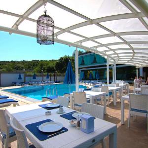 a patio with white tables and chairs and a pool at Bodega Otel Şile in Şile +25 photos