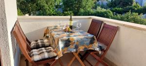 a table with a wine bottle and glasses on a balcony at Green Villa in Banjole