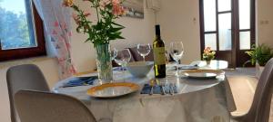 a table with a bottle of wine and wine glasses at Green Villa in Banjole