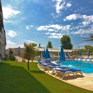a swimming pool with lounge chairs and blue umbrellas at Bodega Otel Şile in Şile