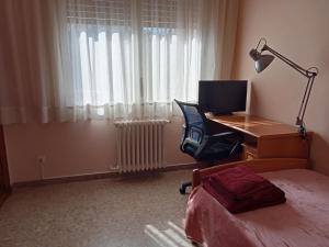 a bedroom with a desk with a computer and a bed at Habitació S Cal Kim in Martorell