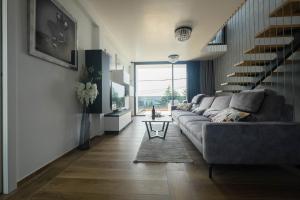 Una sala de estar con un sofá y una escalera. en Villa Skrisia, en Cesarica