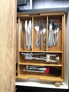 a drawer with utensils in a wooden cabinet at Green peaceful ultra central apartment, 2 bedrooms, Streaming, Workspaces in Cluj-Napoca