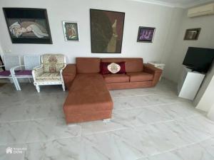 uma sala de estar com um sofá e cadeiras castanhos em Amore Beach элитный готельный комплекс em Elenite