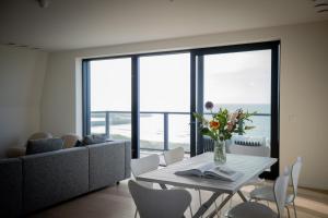 een woonkamer met een tafel en een bank bij La Risacca, Luxurious, 3 bedroom, sea view design apartment in Cadzand +20 foto's
