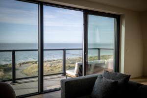 La Risacca, Luxurious, 3 bedroom, sea view design apartment في كادزاند: غرفة معيشة مطلة على المحيط