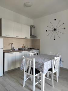 a kitchen with a table and chairs and a kitchen with a clock at Brzica Saplunara in Saplunara +41 photos