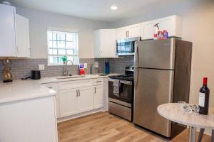 La cuisine est équipée d'un réfrigérateur en acier inoxydable et de placards blancs. dans l'établissement Lovely apartment near Midtown Atlanta, à Atlanta