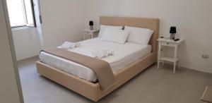 1 dormitorio con 1 cama grande con sábanas y almohadas blancas en La Veranda Beach, en Agropoli