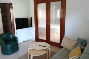 ein Wohnzimmer mit einer Couch, einem Tisch und einem Fernseher in der Unterkunft Luxury Penthouse, 50m2 terrace, downtown in Santa Cruz de Tenerife