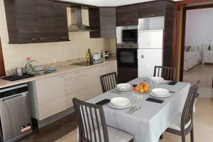 eine Küche mit einem Tisch mit Stühlen und einem weißen Tischtuch in der Unterkunft Luxury Penthouse, 50m2 terrace, downtown in Santa Cruz de Tenerife