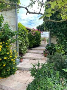 una escalera de piedra que conduce a un jardín con flores en Le Cottage d'Eleanor gîte de charme avec spa Jacuzzi privé, en Marçay