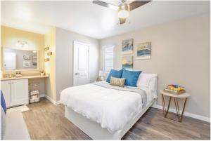 een slaapkamer met een groot wit bed met blauwe kussens bij Cozy Suite w Pool and Free Parking At Phoenix in Phoenix