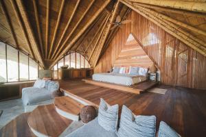 a room with a bed and a couch and chairs at Gitana del Mar Boutique Beach Resort in Buritaca