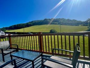 a deck with two chairs and a table on a balcony at Lillypool Lodges in Cheddar