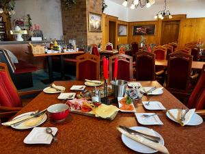 a table with plates of food on it in a restaurant at Hotel Zur Sonne in Falkenstein