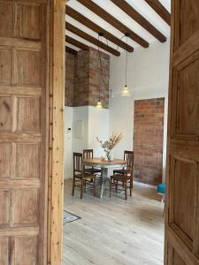 a dining room with a table and chairs and a brick wall at CAN LLAVI - LLAUT in Canet de Mar