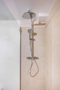 y baño con ducha con cabezal de ducha. en Apartamento Macarena, en el Centro de Sevilla, en Sevilla