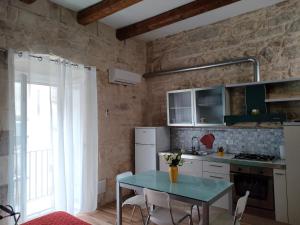 a kitchen with a table with chairs and a window at Bella Giulia in Ragusa