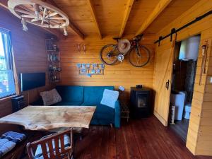 uma sala de estar com um sofá azul e uma bicicleta na parede em Klimatyczny drewniany domek w górach em Lachowice