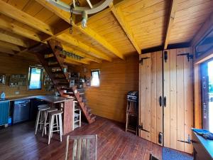 um chalé com paredes de madeira e uma cozinha com um bar em Klimatyczny drewniany domek w górach em Lachowice