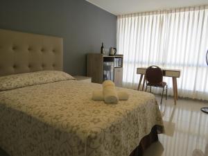 Un dormitorio con una cama con un osito de peluche. en Casa Las Flores Ica, en Ica