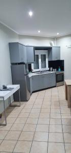 una grande cucina con armadi bianchi e pavimento piastrellato di Nina Apartment a Chania
