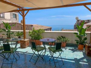 eine Terrasse mit einem Tisch und Stühlen sowie Meerblick in der Unterkunft Guest house Le Sibille in Taormina