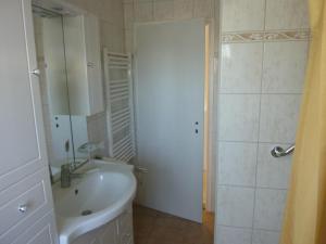 ein weißes Bad mit einem Waschbecken und einer Dusche in der Unterkunft Kleine Sandburg Heiligendamm in Heiligendamm