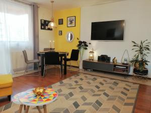 - un salon avec une table et une télévision murale dans l'établissement Orange Water Apartment, à Gdańsk
