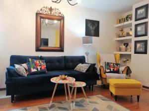 ein Wohnzimmer mit einem blauen Sofa und einem Spiegel in der Unterkunft Orange Water Apartment in Danzig