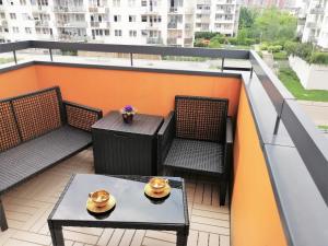 d'un balcon sur le toit avec une table et des chaises. dans l'établissement Orange Water Apartment, à Gdańsk