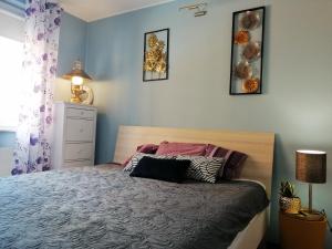 ein Schlafzimmer mit einem Bett und drei Bildern an der Wand in der Unterkunft Orange Water Apartment in Danzig