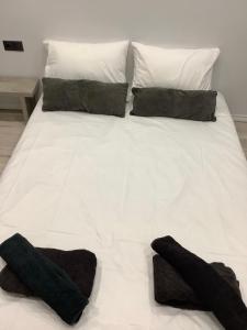 uma cama branca com duas almofadas pretas em New apartment em Tessalônica