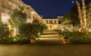 a building with potted plants in front of it at night at Resort Miramonti in Forte dei Marmi