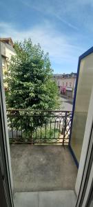 widok na drzewo z okna w obiekcie Joli appartement climatisé w mieście Périgueux