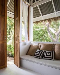a couch in a room with a window at Coconut Beach Bungalows in Chaloklum