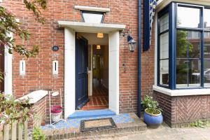 a brick house with a blue door and window at Luxury home in quiet neighbourhood near beach in The Hague
