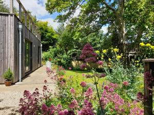 a garden with flowers and a walkway at Garden hideaway, self-contained, edge of Bath in Bath