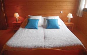 1 dormitorio con 1 cama con almohadas azules y 2 lámparas en Stunning Home In Sceau-saint-angel With Wifi, en Nontron