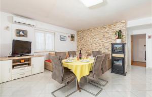 a dining room with a table with chairs and a television at Gorgeous Home In Vodnjan With House Sea View in Vodnjan