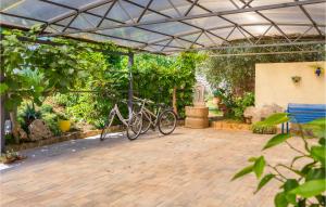 zwei Fahrräder, die unter einem Metalldach in einem Garten geparkt sind in der Unterkunft Gorgeous Home In Vodnjan With House Sea View in Vodnjan
