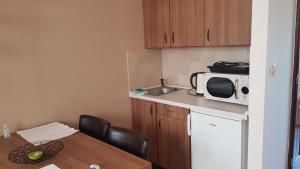 a small kitchen with a table and a microwave at Végvár Delux apartman in Gyula +1 photo