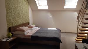 a bedroom with a bed with two pillows on it at Végvár Delux apartman in Gyula