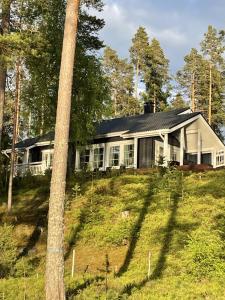 a house sitting on top of a grassy hill at Elegant villa on the shore of Lake Saimaa in Lappeenranta