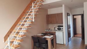 - une cuisine avec un escalier en colimaçon en bois dans l'établissement Végvár Delux apartman, à Gyula