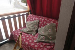 two pillows sitting on a bench next to a window at Studio au calme face aux montagnes dans station de ski in La Morte