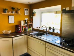 a kitchen with a sink and a window at La Plooz - Chambres, Dortoirs & Océan in Plozévet