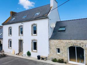 a white house with a black roof at La Plooz - Chambres, Dortoirs & Océan in Plozévet
