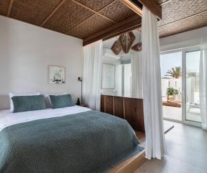 a bedroom with a bed and a large window at ALERÓ Seaside Skyros Resort in Skiros
